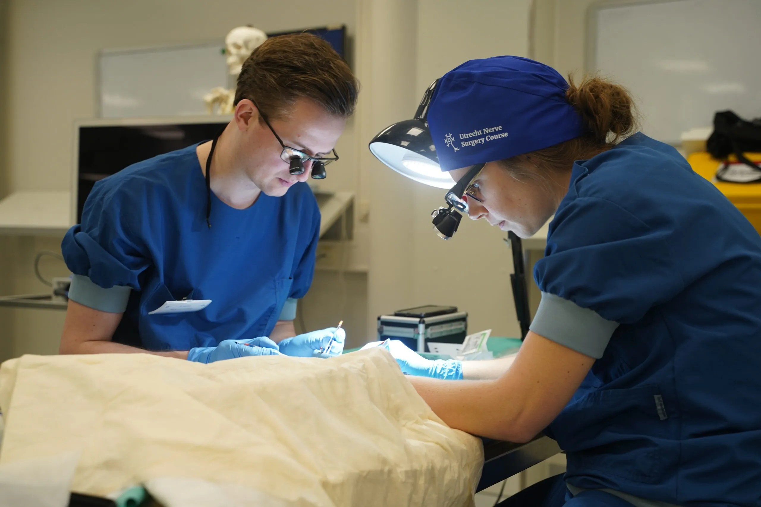Two participants dissecting with surgical loupes and headlights